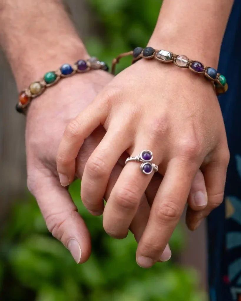 due mani che si stringono con indosso due bracciali Buddhabra dei sette chakra